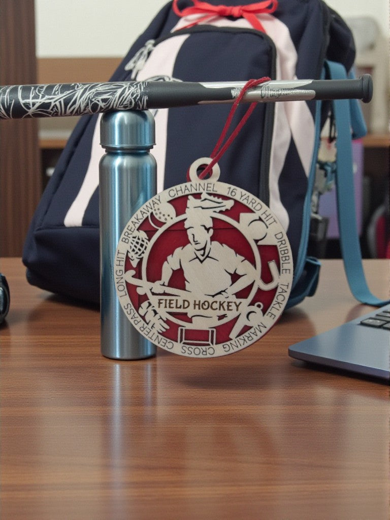 Medal with field hockey design on a water bottle against a desk background