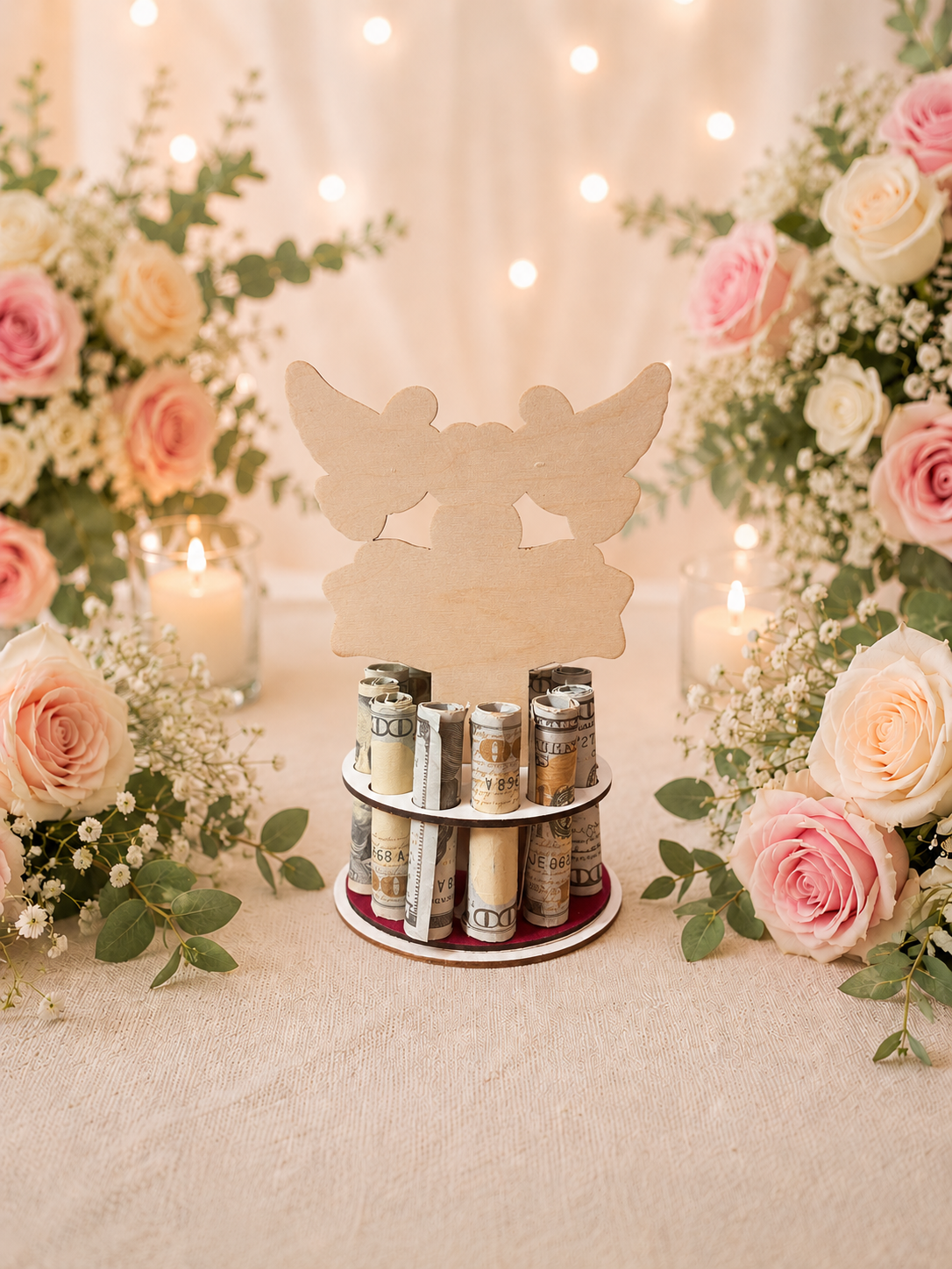 Premium handmade wood dove wedding money tree with hand-painted white doves, hearts, and wedding rings above a banner reading "Congratulations — Wishing you a lifetime of love and happiness," displayed on a circular base holding 12 rolled bills, surrounded by pink and white roses with soft candlelight