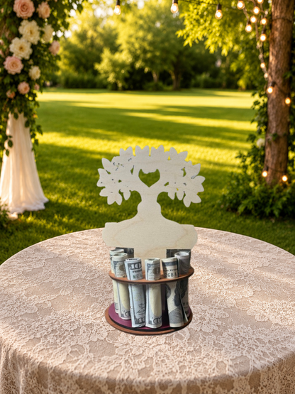 Premium handmade wood tree of life money tree with hand-painted green leaves, heart-shaped trunk cutout personalized with "1st 2026," and Congratulations banner, displayed on a single-tiered base holding 12 rolled bills, styled outdoors with a white rose garden and wedding arch in the background